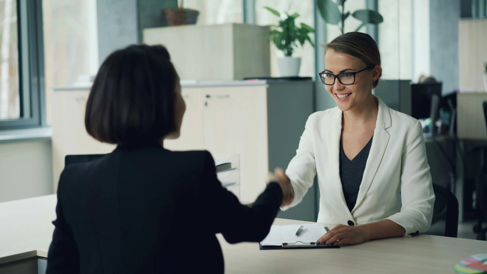 Professionals shaking hands over a contract, sealing a B2B ecommerce partnership